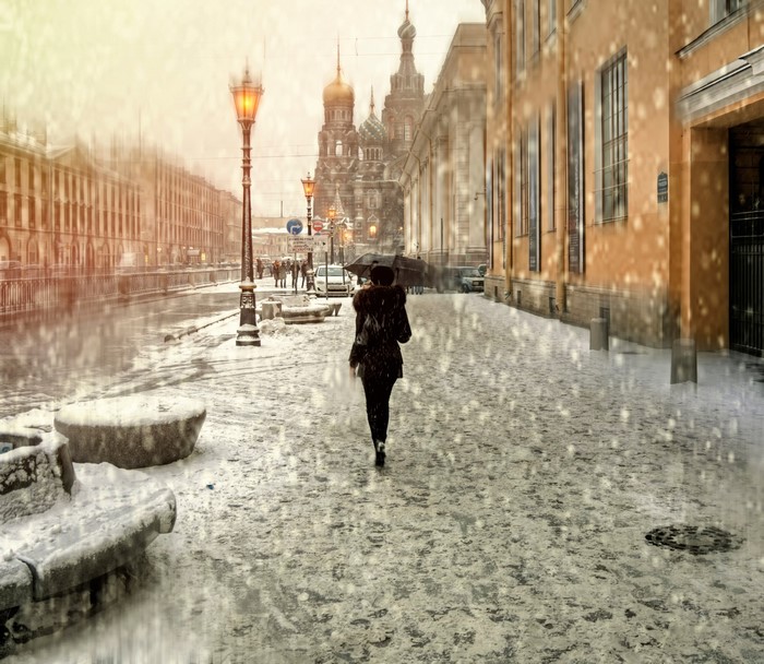 Person with umbrella walking in snowy St. Petersburg