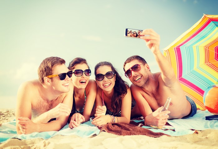 Four friends taking a selfie on the beach