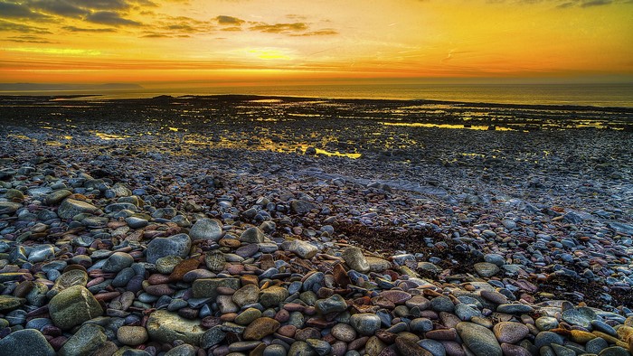Rocky beach at sunset with orange sky