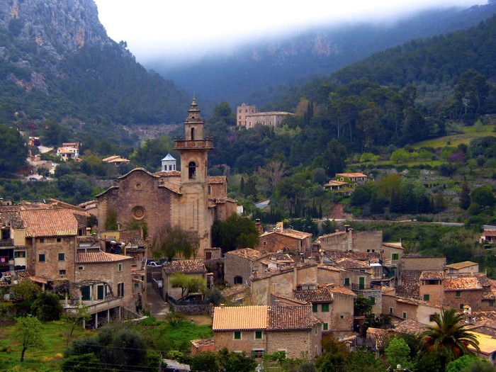 Village nestled in a mountain valley with a church