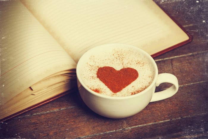 Cup of coffee with heart and open book