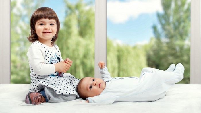 Two young children by a window