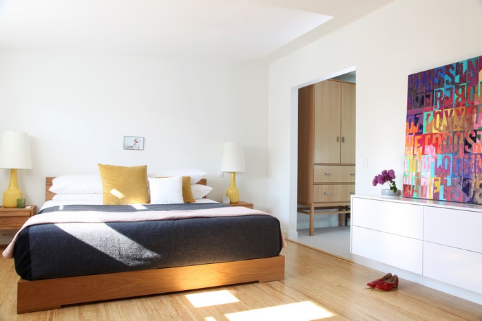 Bedroom with bed, lamps, and artwork