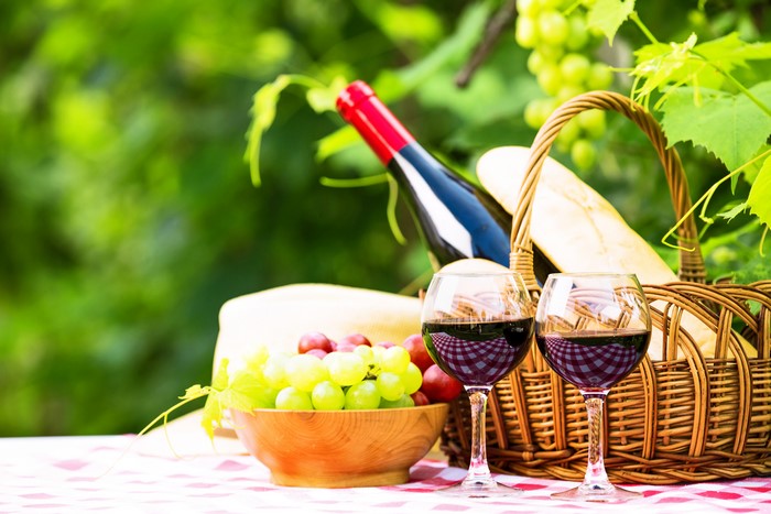 Still-life of wine, grapes, and bread in a wicker basket