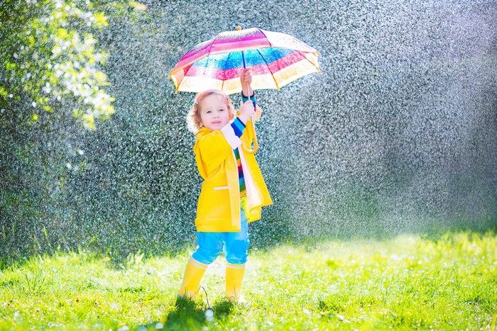 Little girl with umbrella in the rain
