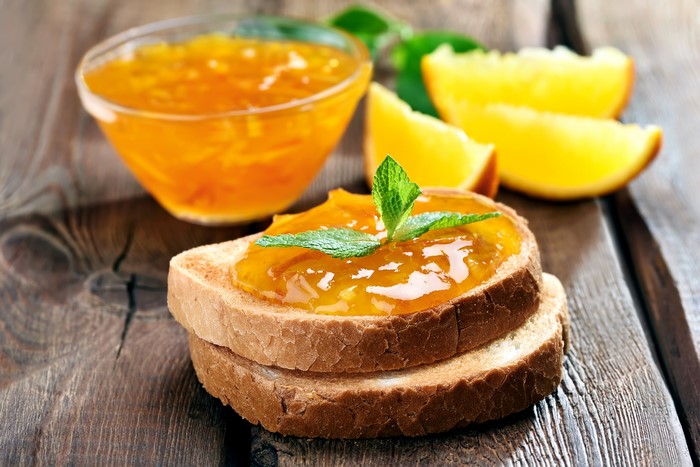 Orange jam on toast with mint and orange slices