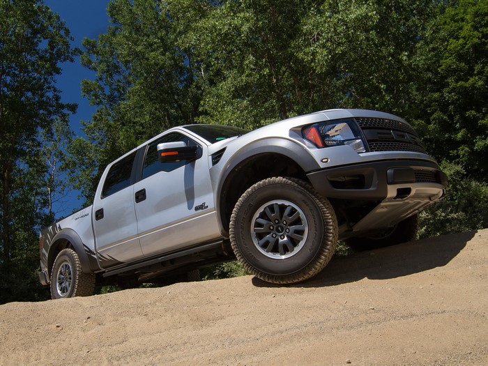 Silver Ford F-150 SVT Raptor truck on dirt road