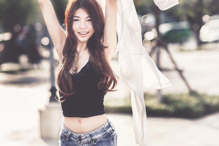 Asian woman in crop top and jeans