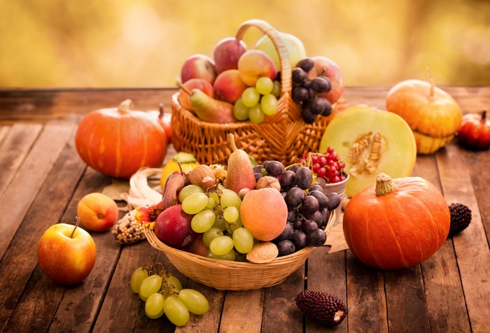 Autumn harvest with pumpkins, grapes, apples, and peaches