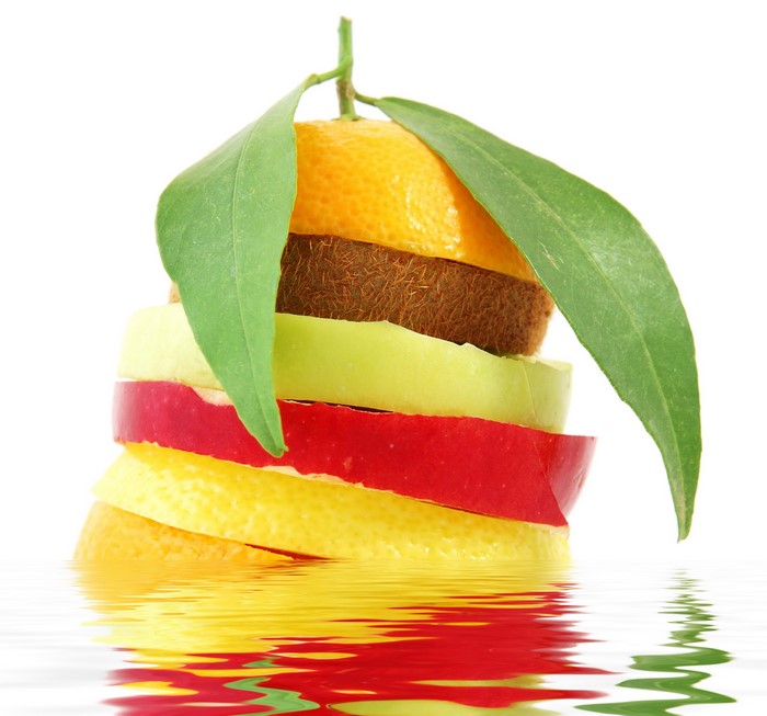 Stack of sliced fruits with leaves and reflection