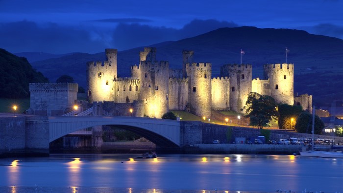 Conwy Castle at night with a bridge over a river