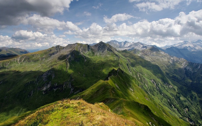 Green mountain range under a cloudy sky
