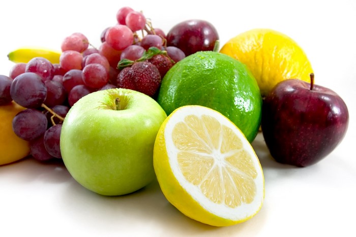 Assortment of fresh fruits including apples, grapes, lemons, and lime