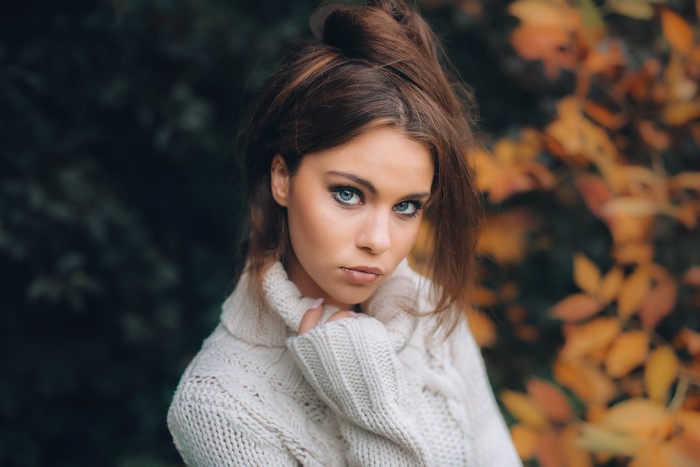 Woman in sweater with autumn leaves