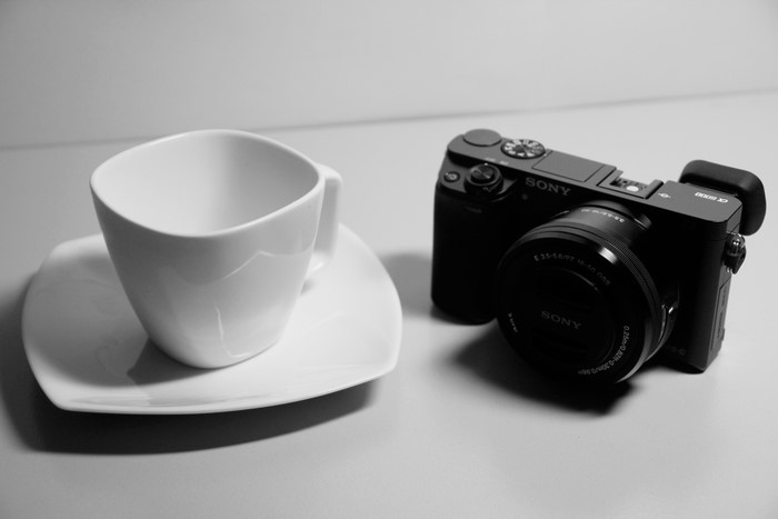 Sony a6000 camera and white cup with saucer