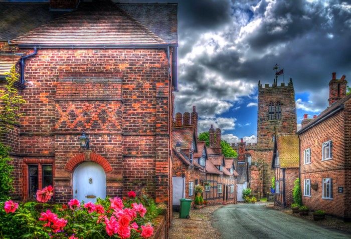 Village street with houses and church in Little Budworth, United Kingdom