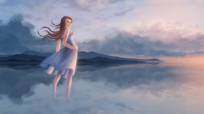 Girl in blue dress standing in water at sunset