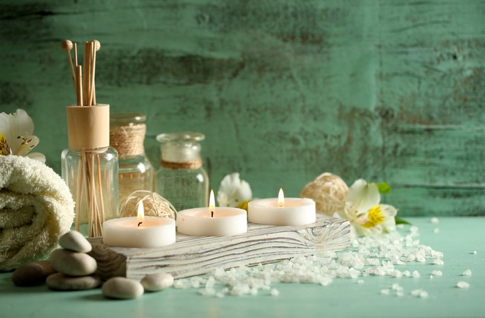 Spa setting with candles, stones, and diffuser