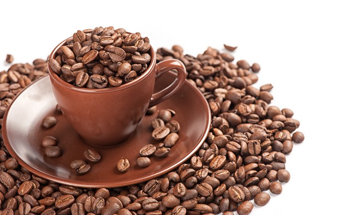 Coffee beans in a cup and saucer