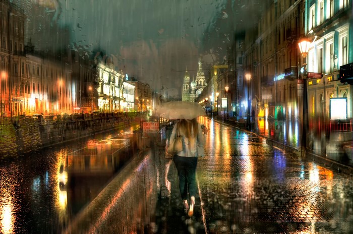 Woman with umbrella walking on a rainy street in St. Petersburg