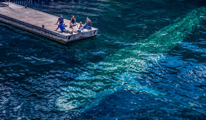 People relaxing on a dock by the sea