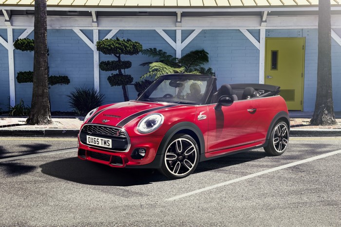 Red Mini Cooper S Convertible parked outside a blue building