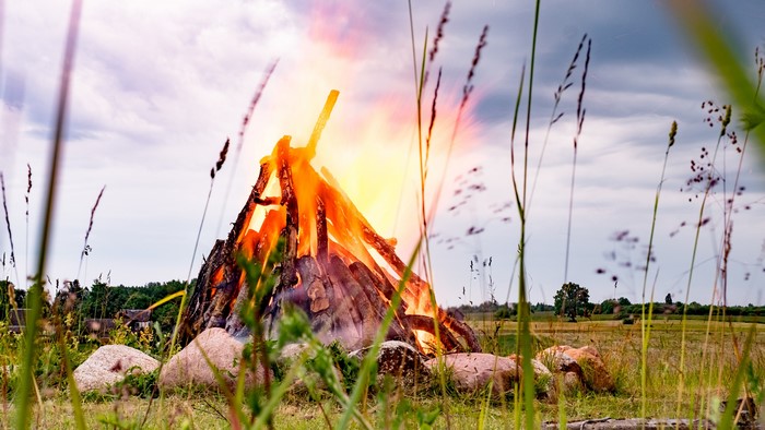 Large bonfire with stones and grass