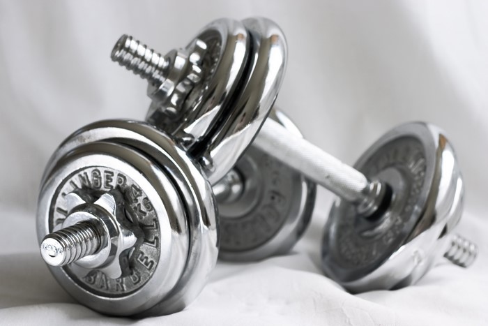 Two chrome dumbbells on a white surface