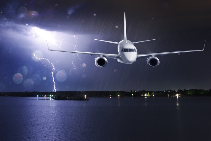Airplane flying through a thunderstorm at night