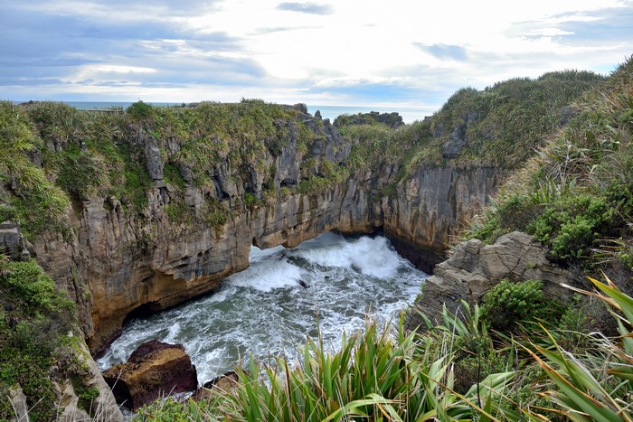 Waves crashing through rock archway at Punakaiki