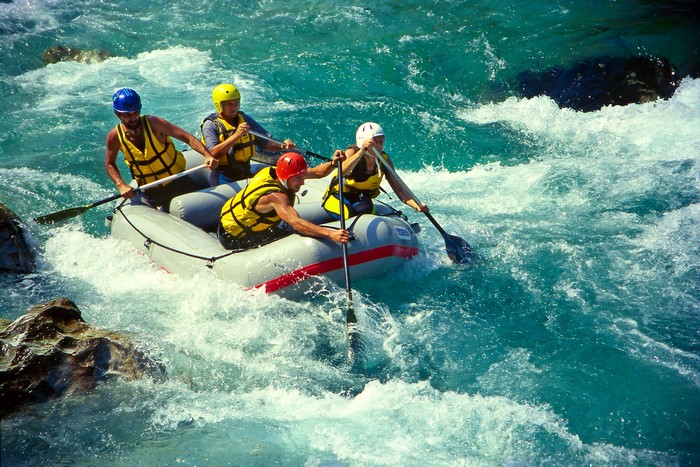 People white water rafting in a river