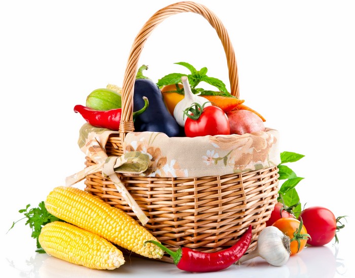 Wicker basket filled with fresh vegetables and corn