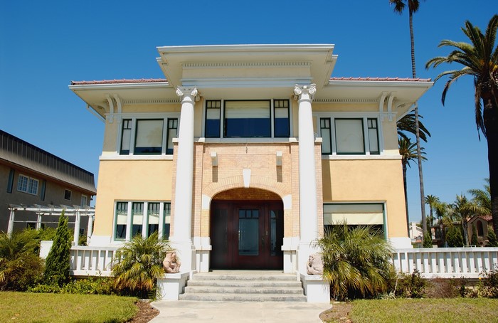 Yellow mansion with columns and palm trees