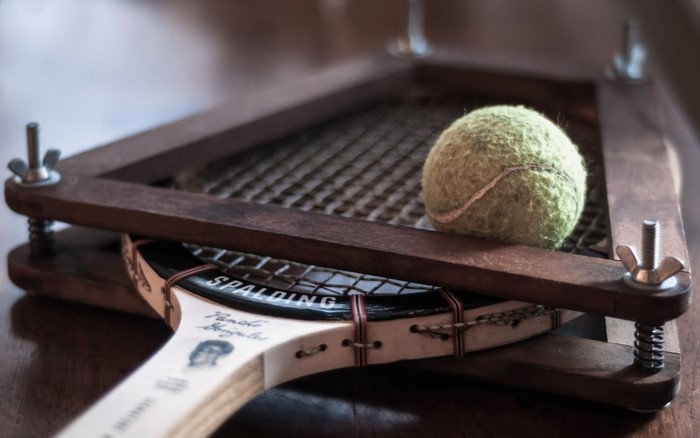 Tennis racket and ball in a stringing machine