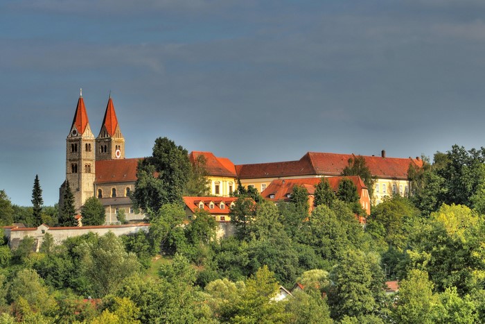 Monastery and church with red roofs surrounded by trees