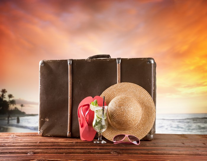 Summer vacation items on a wooden table at sunset