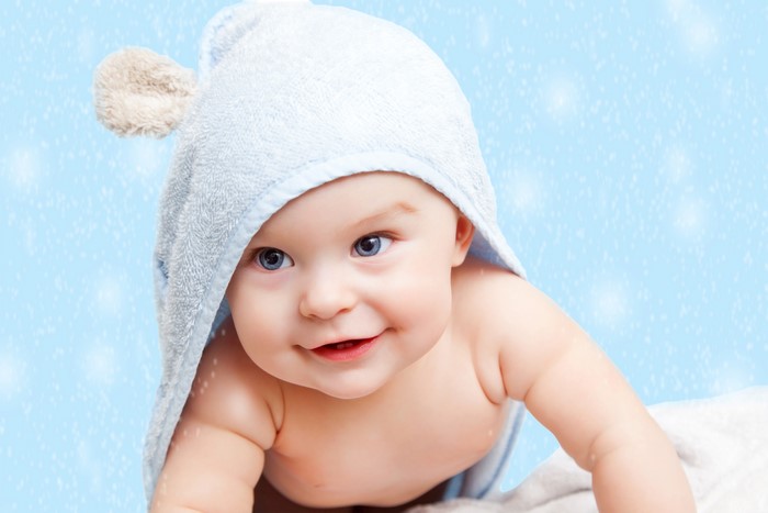 Baby wearing a blue hooded towel with bear ears