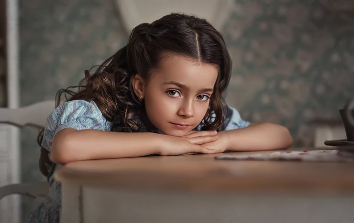 Thoughtful Young Girl Resting on Table