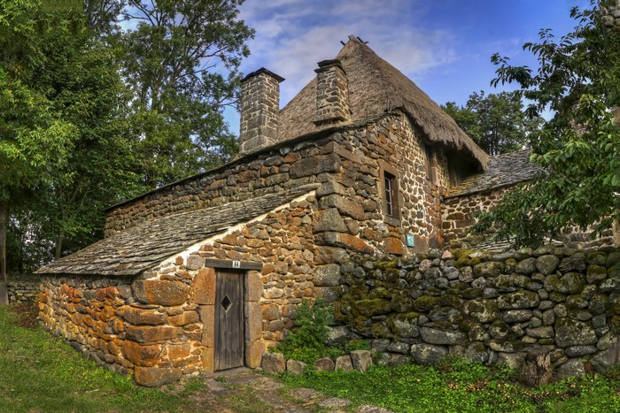 Stone house with thatched roof in Moudeyres Auvergne, France