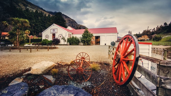 White building with red roof and wagon wheels
