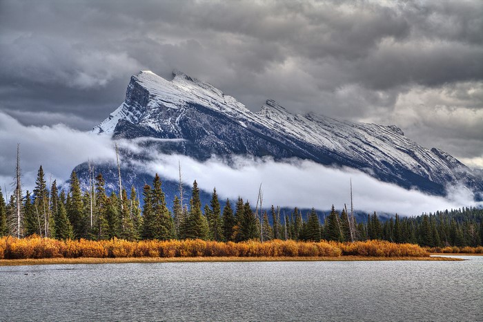 Snow-capped mountains over a lake and forest