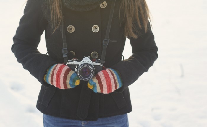 Person holding a Pentax camera in winter