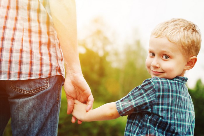 Boy holding hands with father