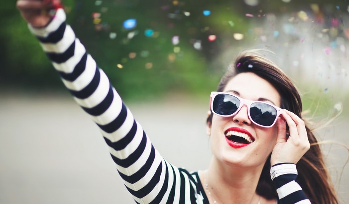 Woman in striped shirt and sunglasses with confetti