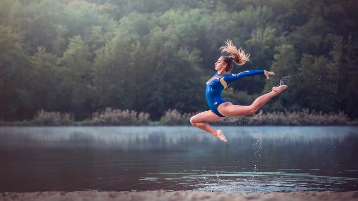 Alexiane performing a gymnastics jump over water