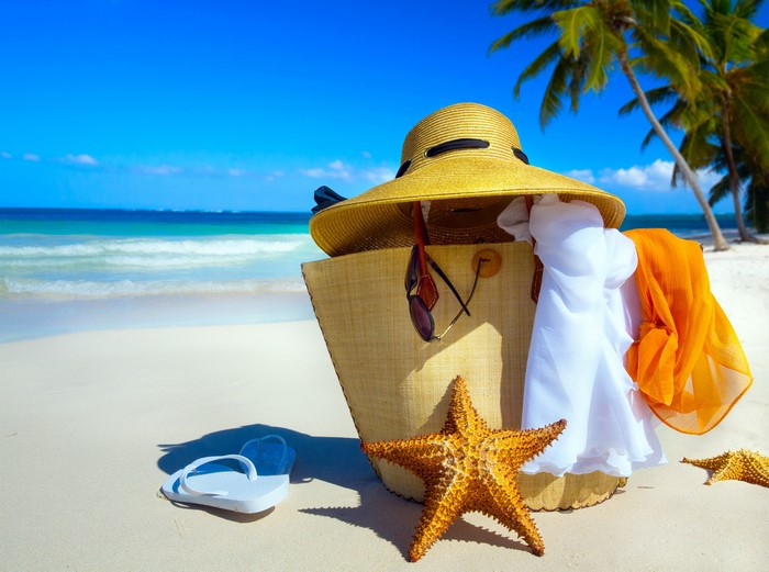 Beach scene with starfish, handbag, hat, and flip-flops