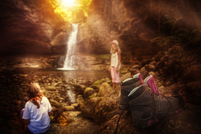 Two girls and boots by a waterfall