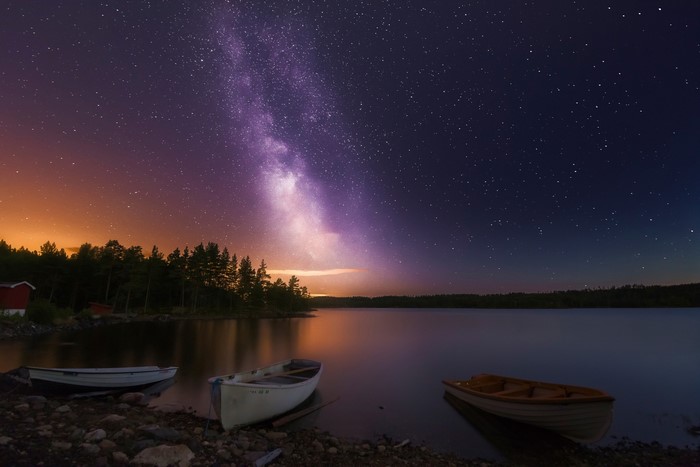 Boats on a lake under the Milky Way in Norway