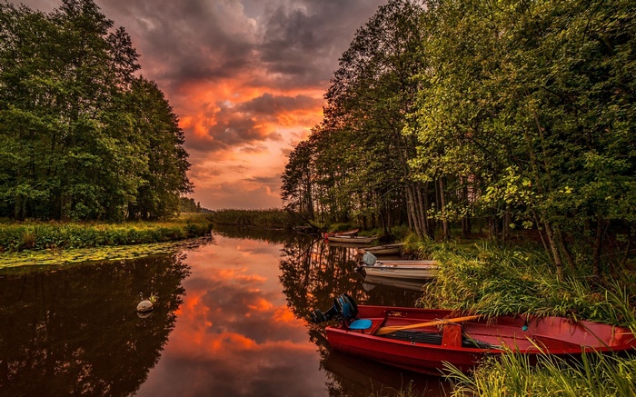 Boats on a river during a fiery sunset