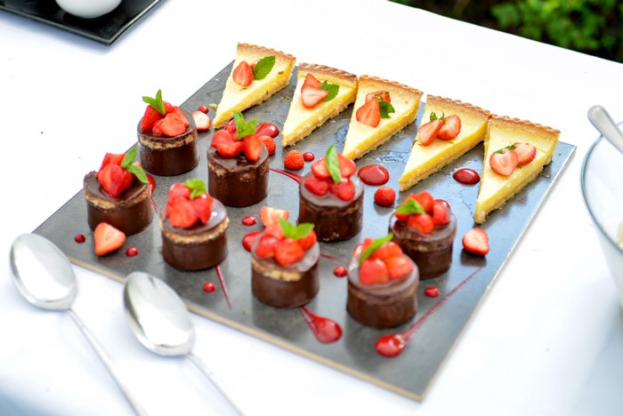 Strawberry tarts and chocolate cakes on a platter